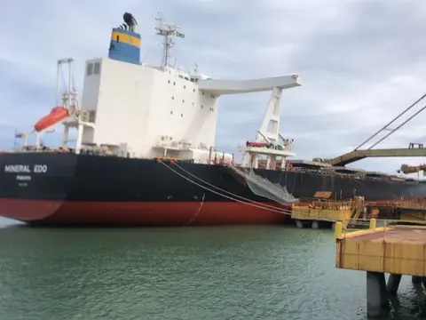 Navio graneleiro atracado num terminal portuário